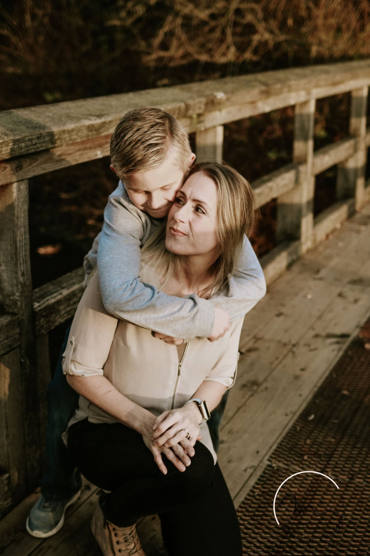 Mother and son hugging on a wooden bridge — McManus Photography