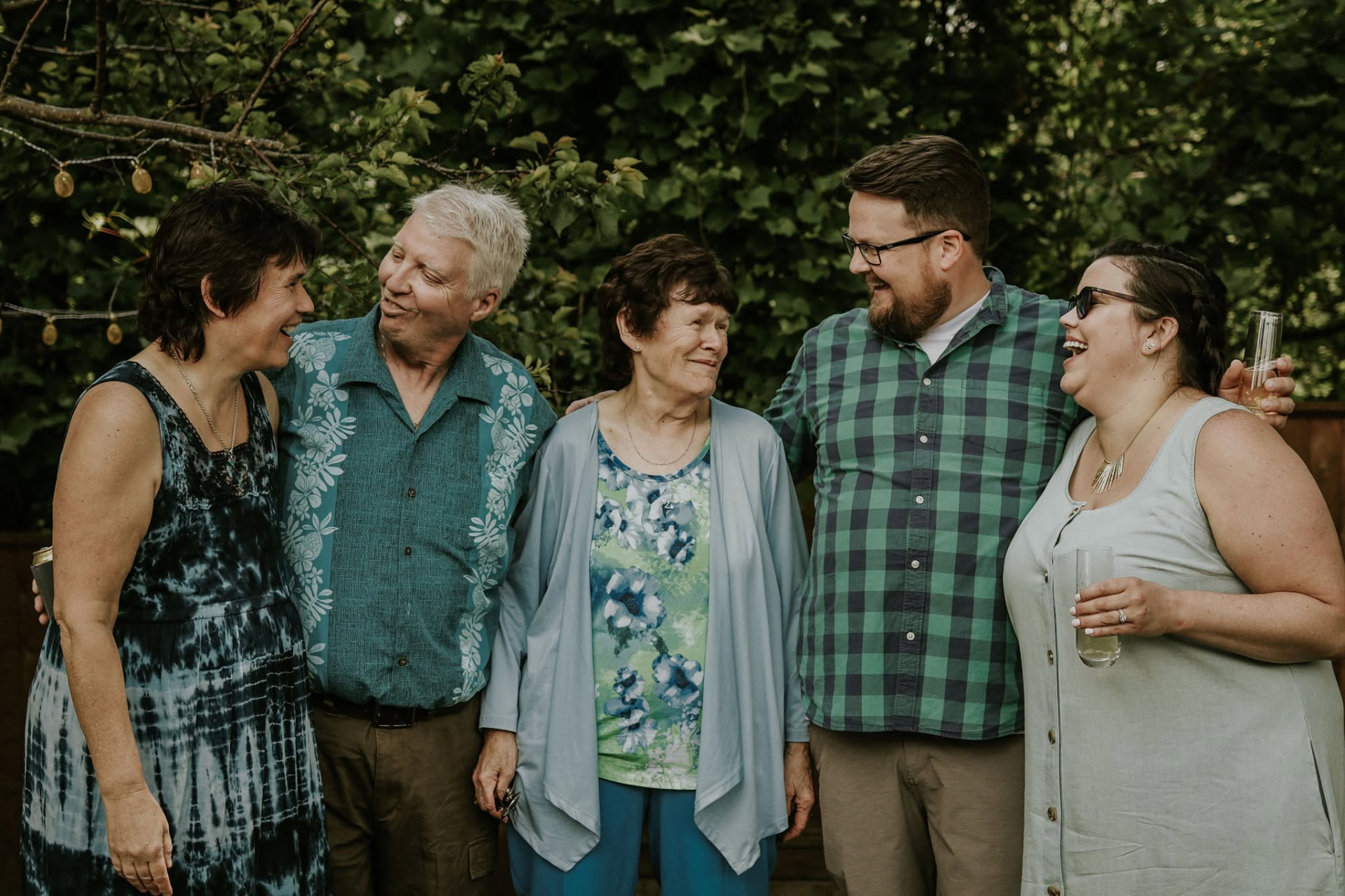 Family gathered in a backyard garden, sharing a laugh — McManus Photography