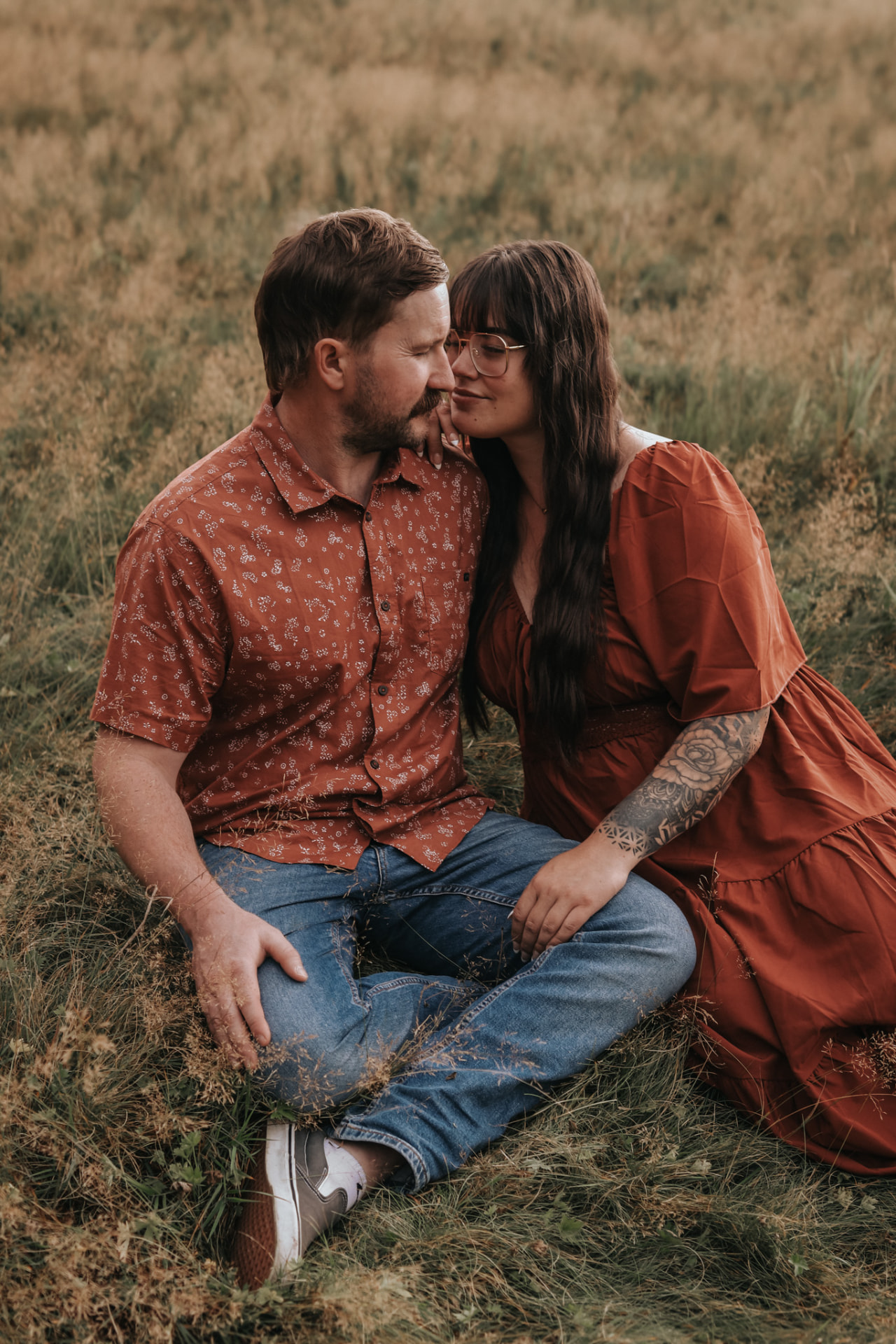 Couple sitting close together in tall grass