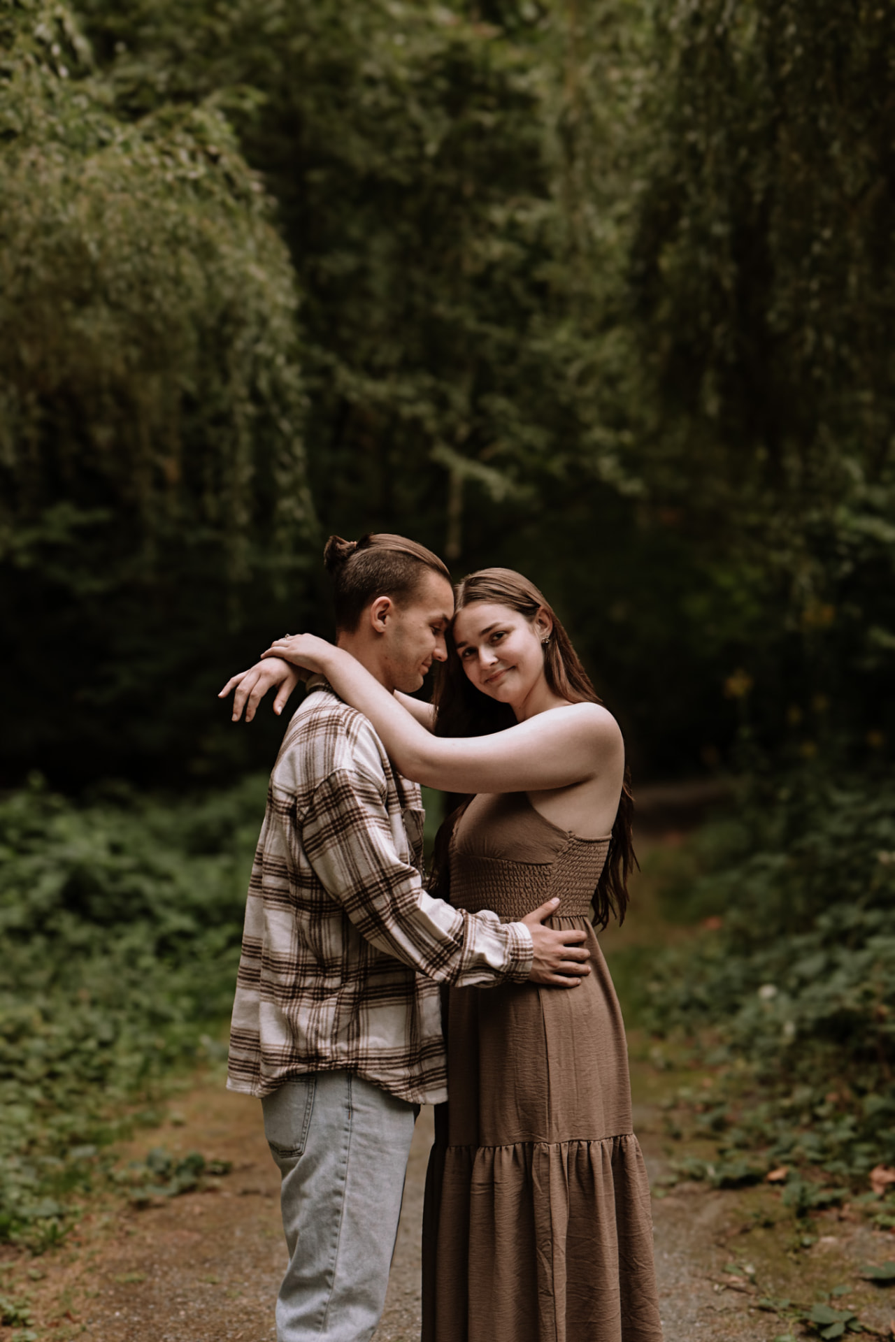 Couple embracing on a forest path