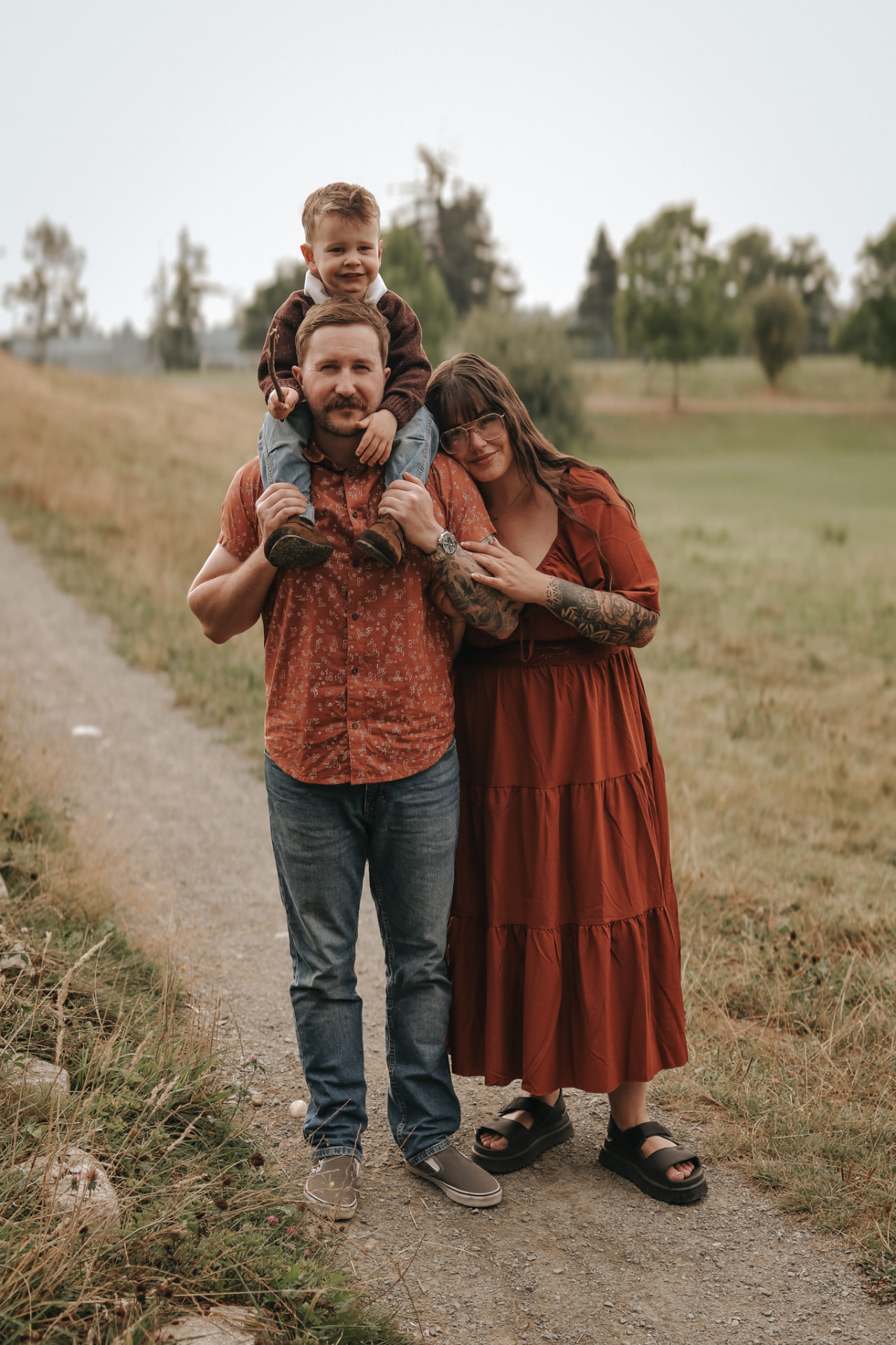 Family on a country path with son on dads shoulders