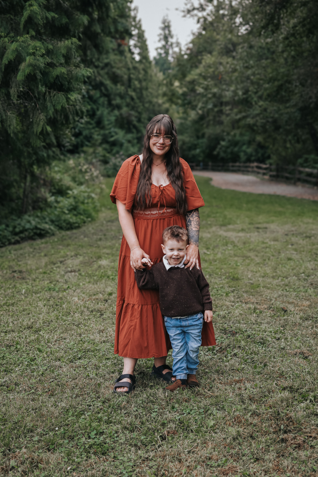 Mother and son standing on a forest path