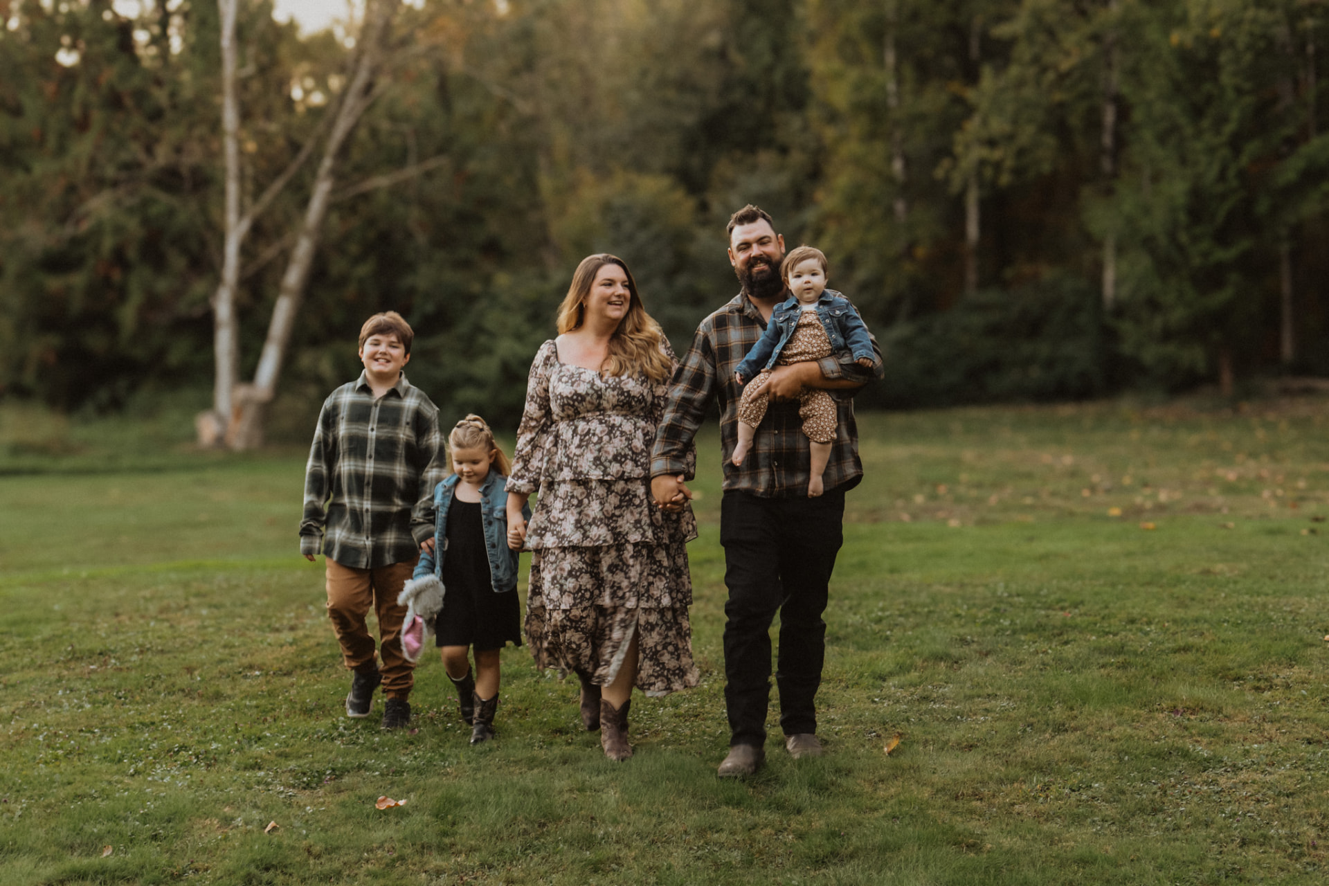 Family walking hand in hand across a grassy field