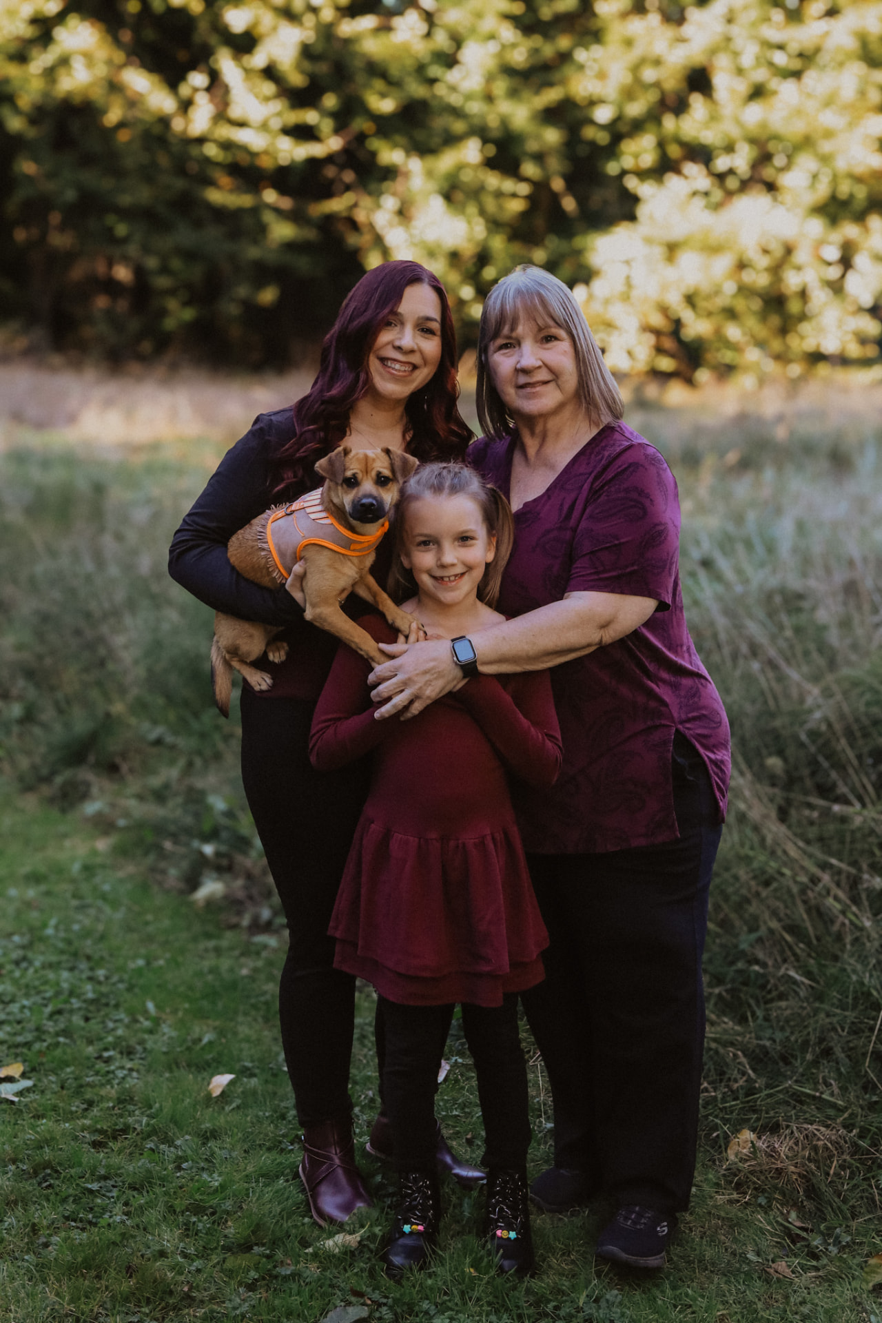 Grandmother, mother and daughter with their puppy at sunset