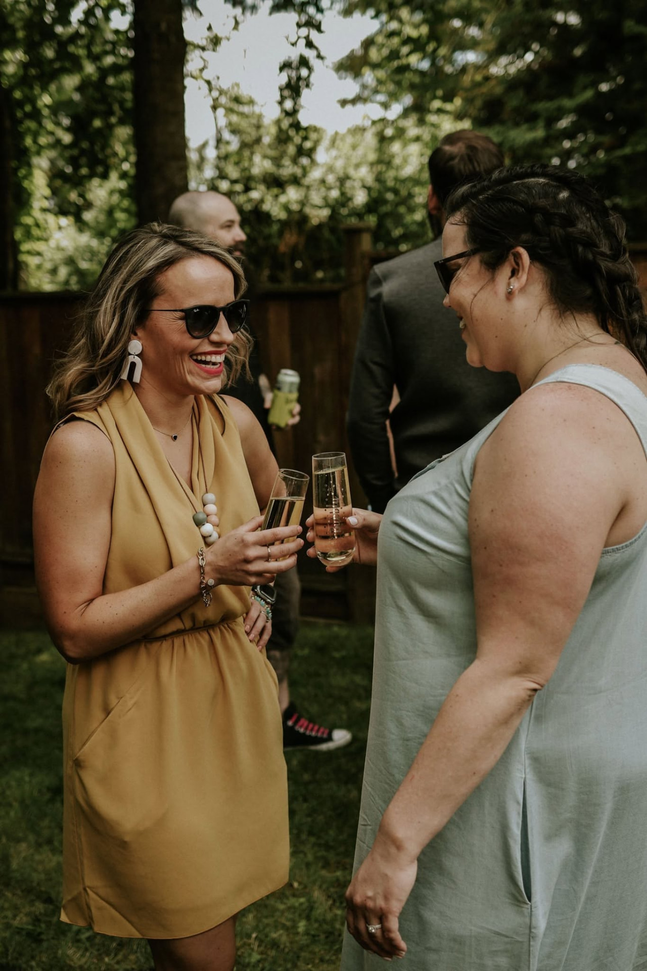 Two guests laughing over champagne at a wedding reception