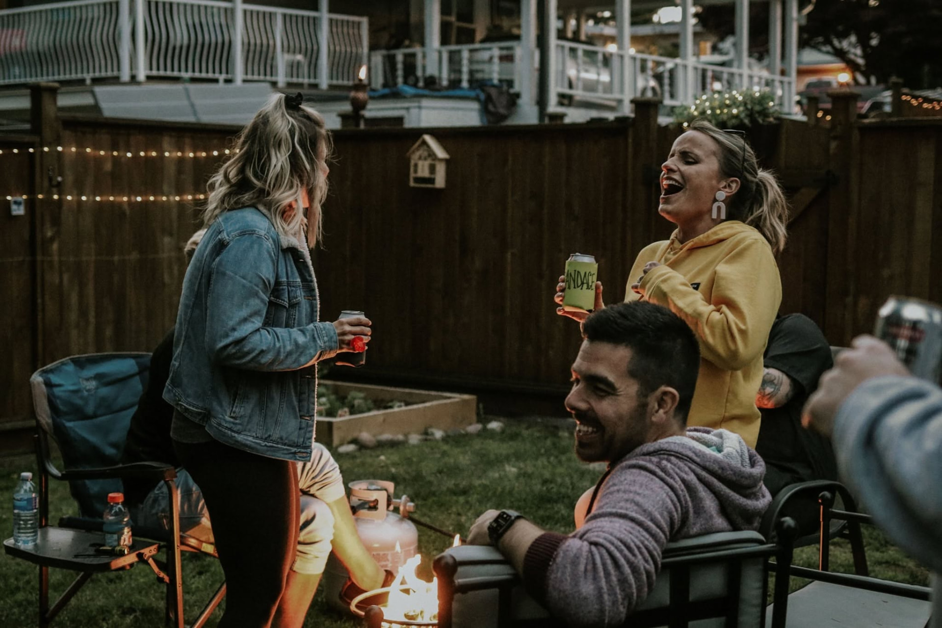 Guests laughing around a backyard fire pit after the reception