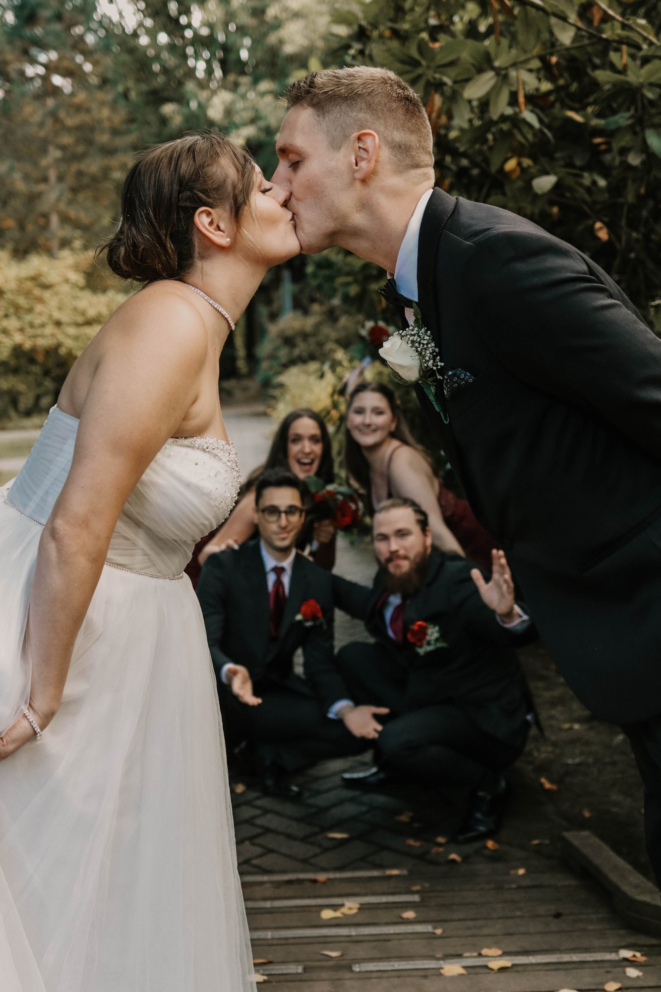 A kiss with the wedding party on the bridge — McManus Photography