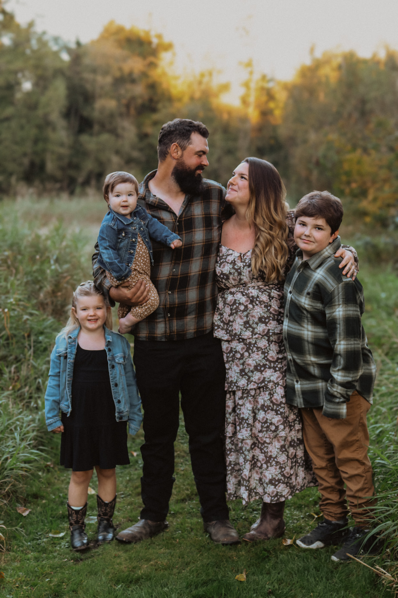 Family of five standing together in a golden field