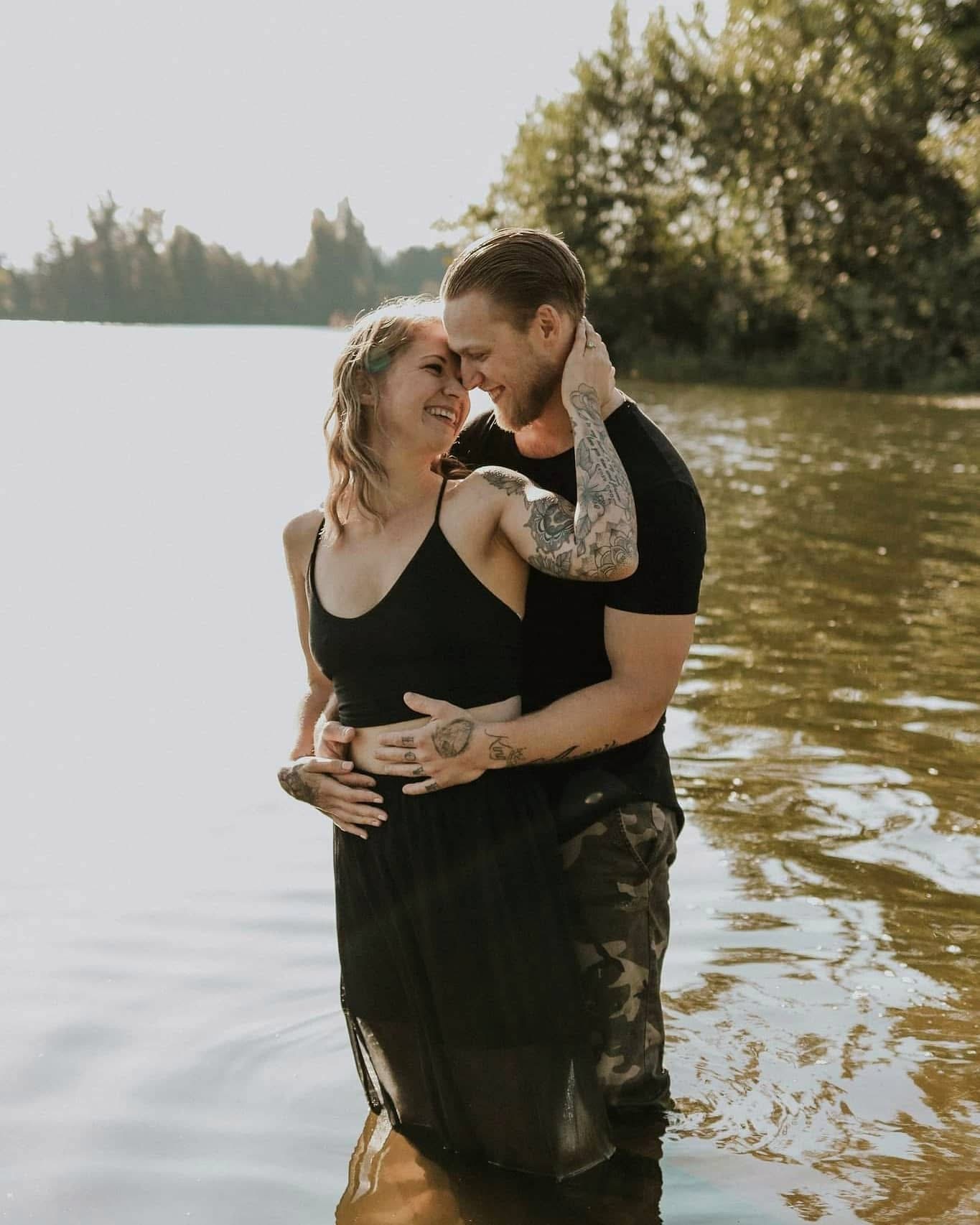 Couple laughing while standing in a lake at golden hour — McManus Photography